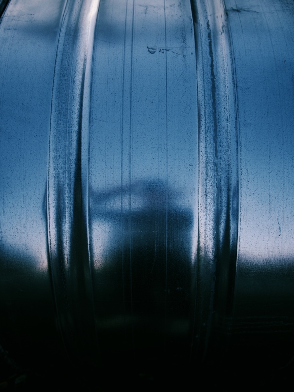 Photograph. A reflection on a metal tub.